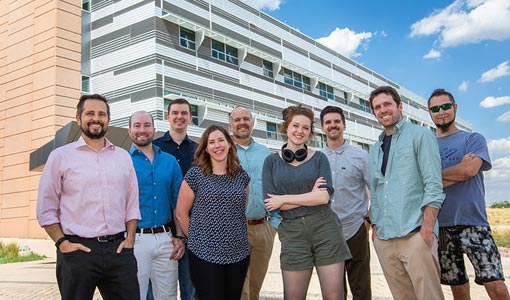 Nine people outside a research facility.