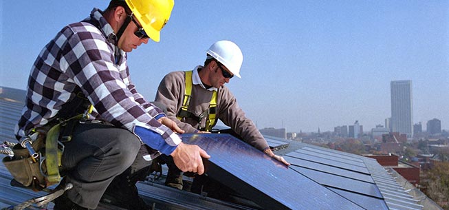 Two men installing solar panels