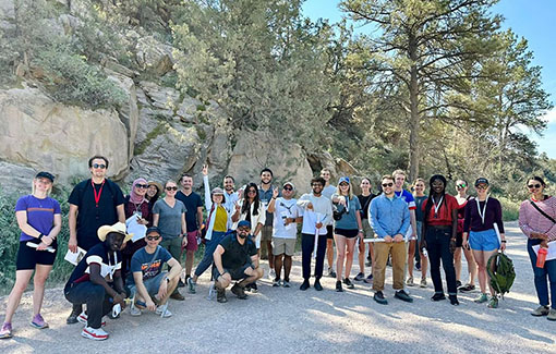 A large group poses on a hiking trail.