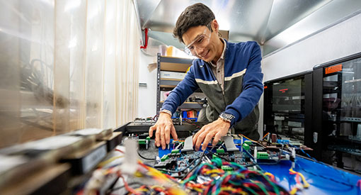 Person working on grid wires inside lab