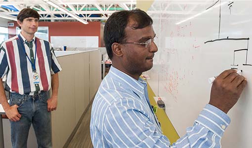 NREL engineers map out a grid model on a whiteboard.