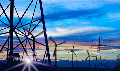 Photo of transmission lines near a series of wind turbines.