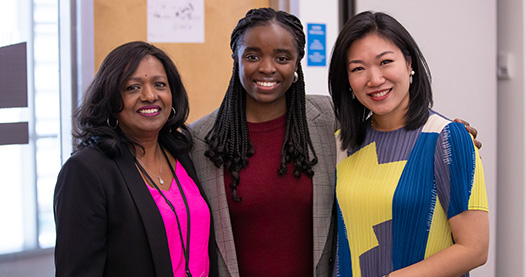 Three people stand together for photo.