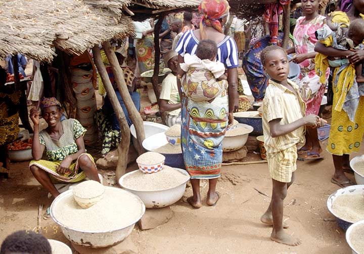 Shoppers and vendors gathered at a busy outdoor market in Ghana.