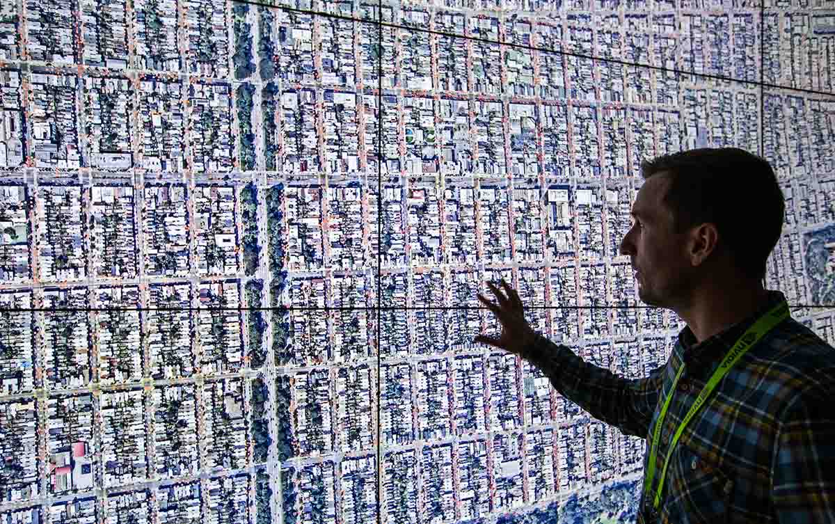 A man interacts with a visualization projected on a large screen.