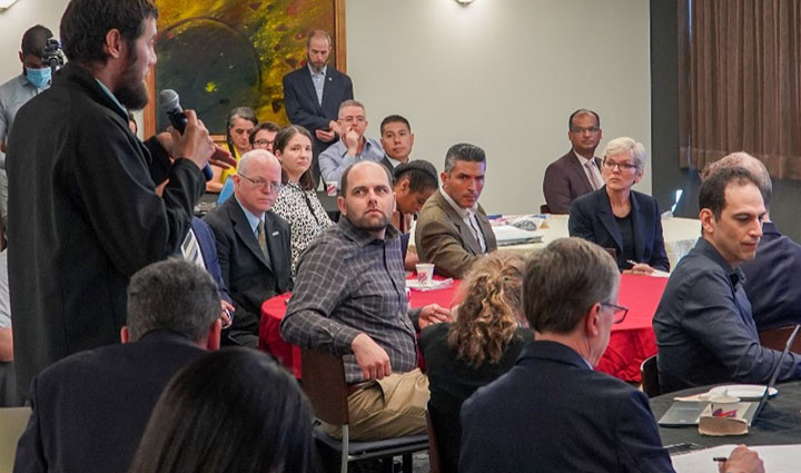 A man speaking to an audience indoors.