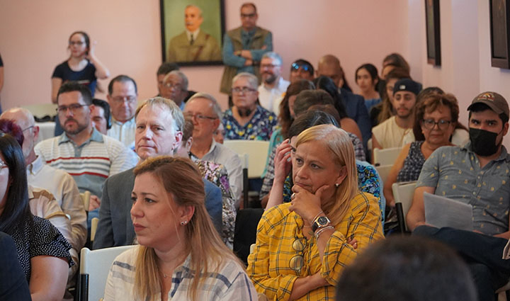 A large group of people listening to someone speak.