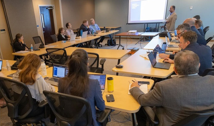 A large group of people sitting around a conference table.