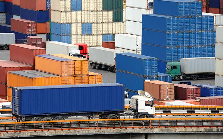 Truck carries container to warehouse near the sea