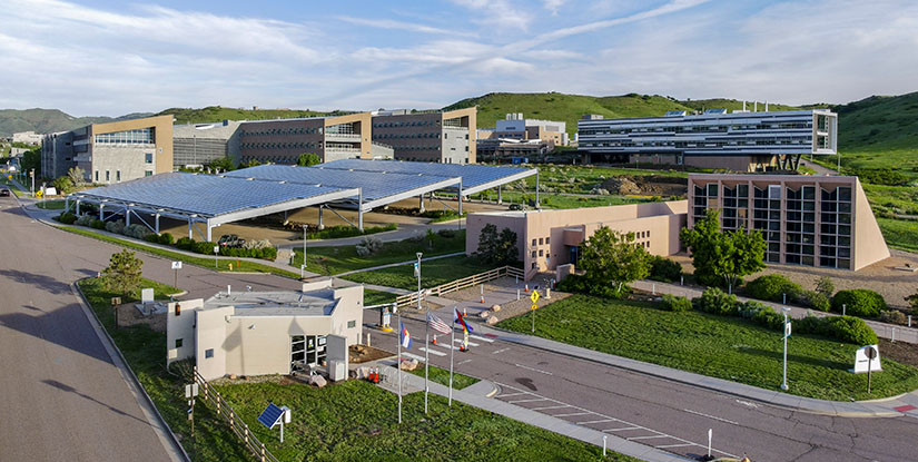 Aerial view of scientific laboratories with green mountains in the background.