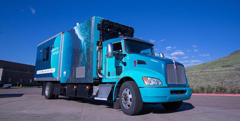 A right-side profile of the H2Rescue vehicle parked on NREL’s campus in Golden, Colorado, with the text “Powered by Hydrogen” on the side of the truck bed and “H2Rescue” near the front wheel well.