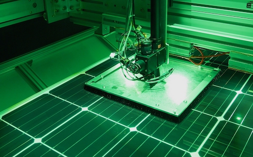 A solar module sits underneath a square shade that covers several cells around the measured cell. A bundle of black fibers runs from LEDs to the center of this shade to measure the desired cell.