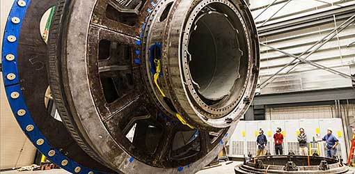 Researchers stand next to large piece of machinery