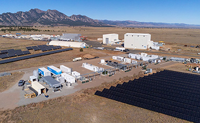 Aerial view of NREL's campus with energy storage buildings and solar arrays.