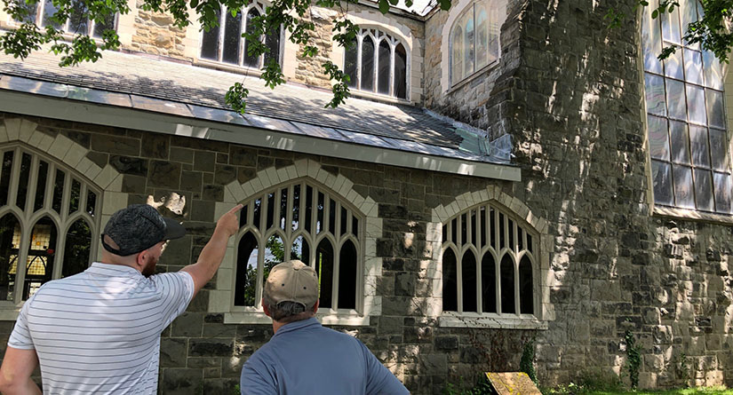 People pointing to roof of church building