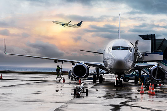 A commercial airplane is fueled while waiting for passengers.