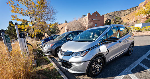 Electric vehicles charging in a parking lot.