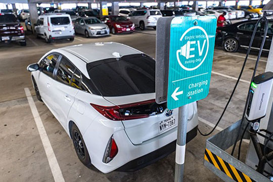 Electric rental vehicle charging at a charging station.