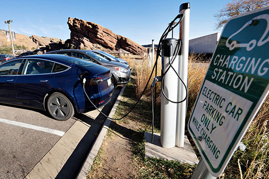 An EV parked at a parking lot charging station.