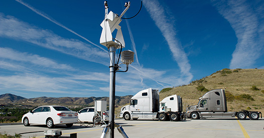 Photo of two cars and three semi-trucks parked near a testing meter.