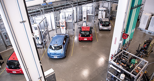 An aerial view of four light-duty electric vehicles plugged in and charging.