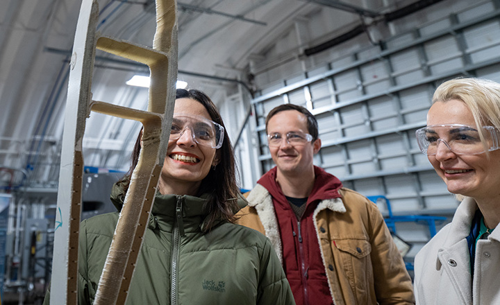 Three people smiling in a lab.