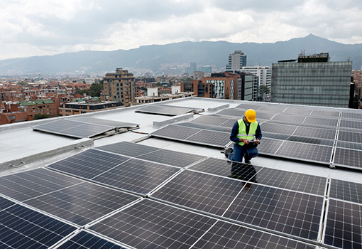 Person on a roof in the middle of solar panels