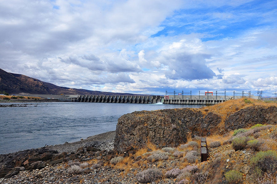 Lake shoreline with hydropower dam in the background.