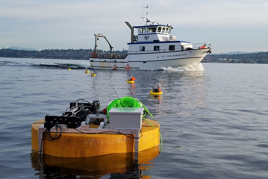 Marine energy technology in ocean in front of ship.