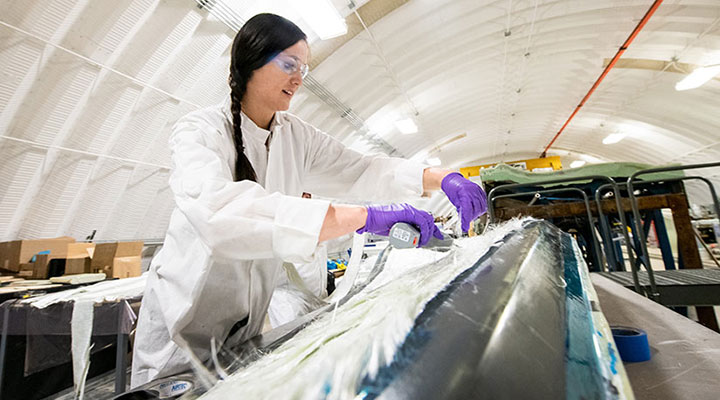 Person working inside the Composites Manufacturing Education and Technology Facility