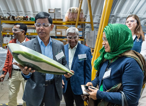 Two people look at a green and white object that one person holds.